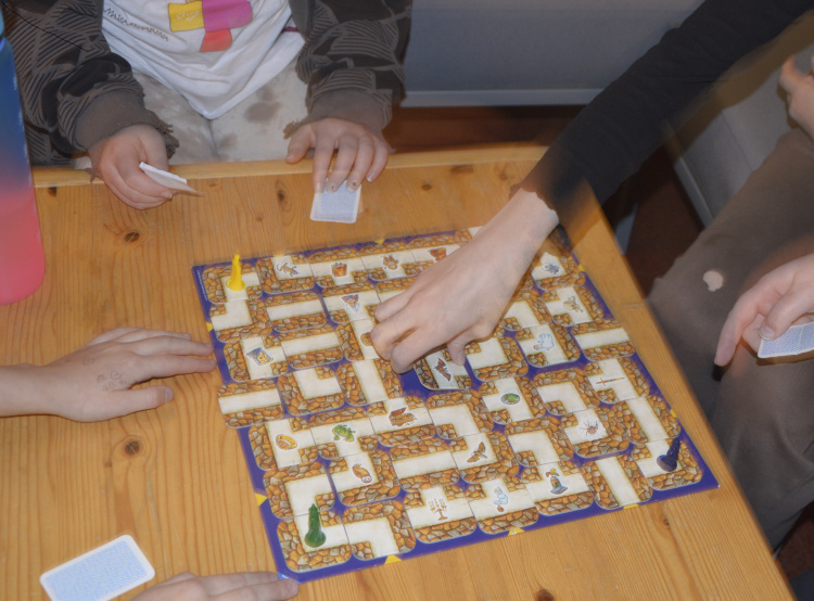Lapset pelaavat labyrintti-lautapeliä